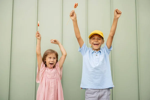 Portret Szczęśliwych Dzieci Słodkimi Cukierkami Zielonym Tle Ścian Świeżym Powietrzu — Zdjęcie stockowe