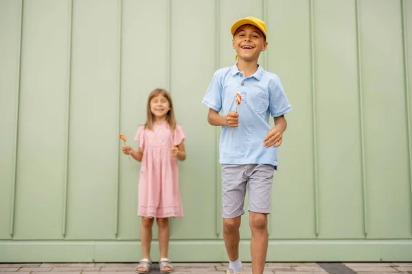 Muotokuva Onnellisista Lapsista Makeiden Makeiden Makeisten Kanssa Vihreällä Seinällä Ulkona — kuvapankkivalokuva