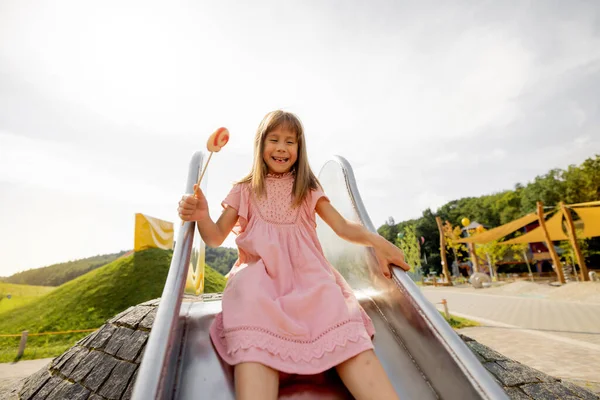 Tyttö Menee Alas Lasten Liukumäkeä Huvipuistossa Leikkikentällä Kesäloman Lasten Viihteen — kuvapankkivalokuva