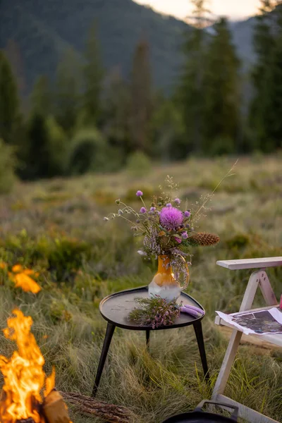 สถานท งแคมป สวยงามและสงบด วยไฟและดอกไม บนโต ะในภ เขา — ภาพถ่ายสต็อก