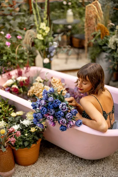 งนอนในอ างอาบน ชมพ อมดอกไม มากมายในสวนกลางแจ แนวค ดเร องความงาม การบ วยดอกไม — ภาพถ่ายสต็อก