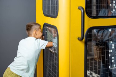 Bilim müzesinde interaktif bir modelde fizik ve elektrik eğitimi alan küçük bir çocuk. Çocuk eğlencesi ve öğrenme kavramı