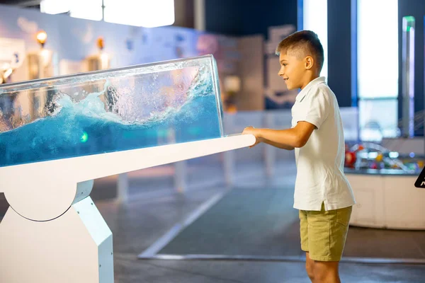 小さな少年は 科学博物館を訪問しながら物理現象を示すモデルに物理学をインタラクティブに学ぶ 児童エンターテインメントと学習の概念 — ストック写真