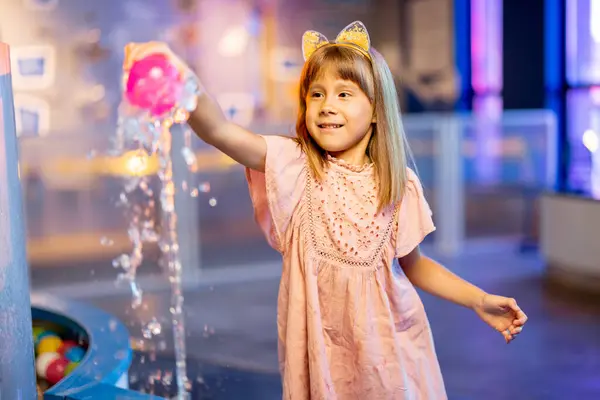 小さな女の子は水の蒸気にボールで遊び 興味深い方法で物理現象を学び インタラクティブなモデルを持つ科学博物館で楽しんでいます — ストック写真