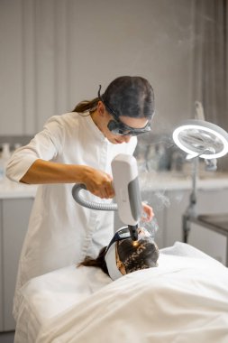 Kozmetik uzmanı güzellik salonunda kadınların yüzüne lazer karbon soyuyormuş. Güzellik yüz bakımı kavramı
