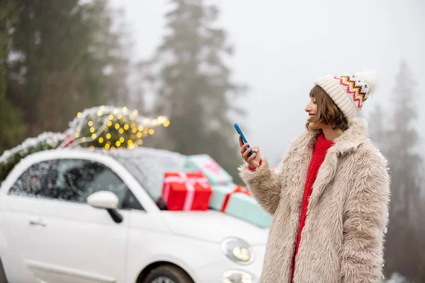 Женщина Путешествуя Телефону Автомобиле Украшенном Подарками Рождественской Елкой Горах Девушка — стоковое фото