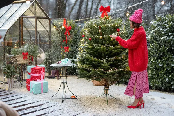 Ung Kvinne Rødt Dekorerer Frodig Juletre Med Festlige Ballonger Krans – stockfoto