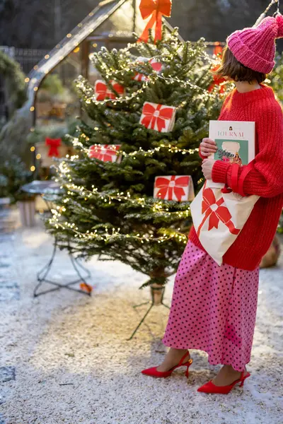 Woman Christmas Tree Decorated Big Red Bows Holding Bag Magazine — Stock Photo, Image