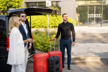 Minibüs taksisinde bekleyen bir çift, şoförlerini ya da kapıcılarını bavullarını taşımaları için bekliyorlar. İş gezileri ve seyahat kavramı