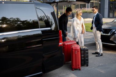 Minibüs taksisinde bekleyen bir çift, şoförlerini ya da kapıcılarını bavullarını taşımaları için bekliyorlar. İş gezileri ve seyahat kavramı