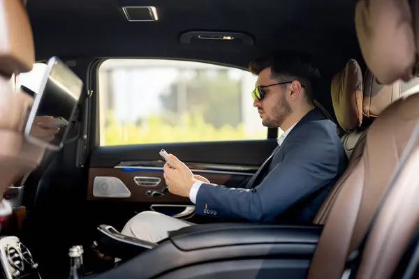 Бізнесмен Сидить Телефоном Задньому Сидінні Розкішного Автомобіля Чоловік Займається Бізнесом — стокове фото