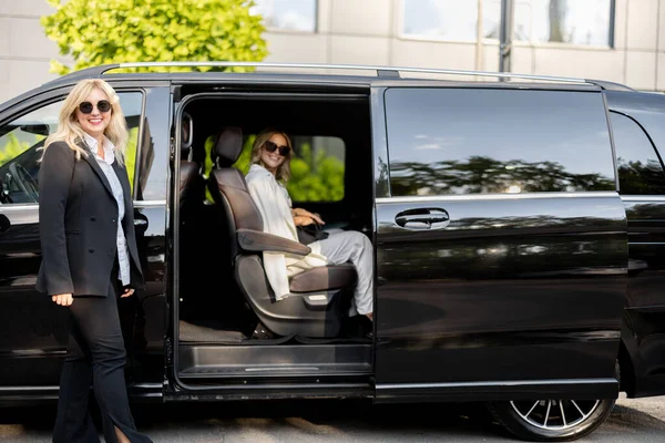 Female Chauffeur Helps Business Lady Get Out Vehicle Opening Door — Stock Photo, Image