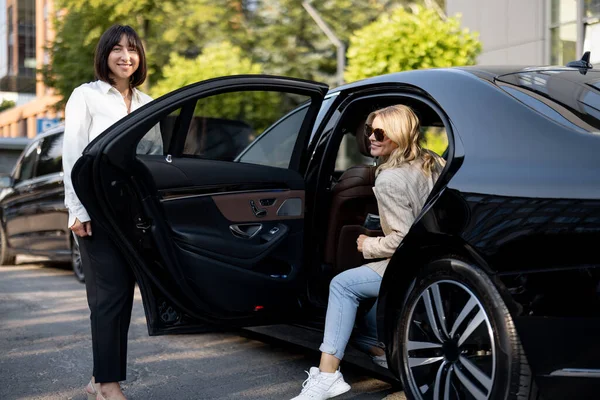 Sopir Wanita Membantu Seorang Wanita Bisnis Untuk Keluar Dari Mobil — Stok Foto