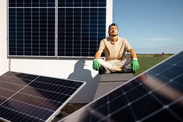 Mies Istuu Talonsa Katolla Johon Asennettu Aurinkovoimala Uusiutuvan Vihreän Energian — kuvapankkivalokuva