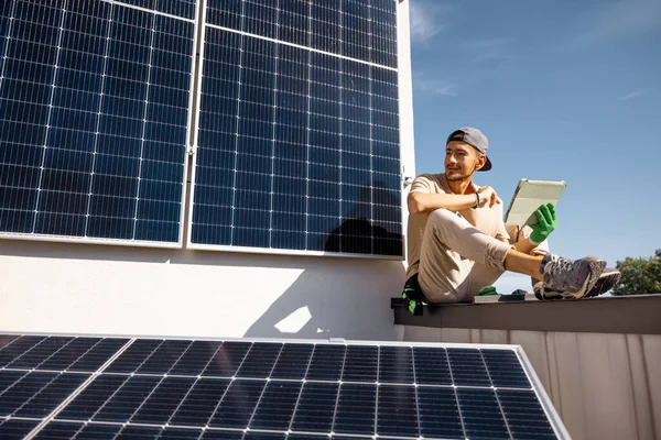 Mies Istuu Katolla Käyttää Digitaalista Tablet Monitorointityötä Kiinteistöönsä Asennetusta Aurinkovoimalasta — kuvapankkivalokuva