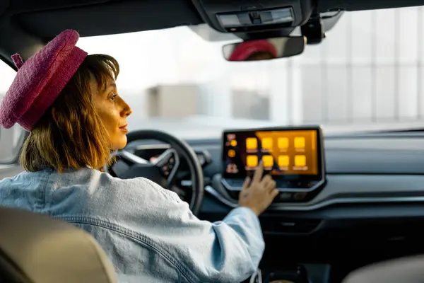 Perempuan Menggunakan Layar Sentuh Saat Mengendarai Mobil Listrik Modern Kota — Stok Foto