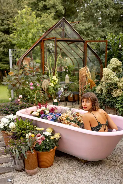 งนอนในอ างอาบน ชมพ อมดอกไม มากมายในสวนกลางแจ แนวค ดเร องความงาม การบ วยดอกไม — ภาพถ่ายสต็อก