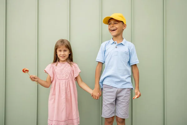 Muotokuva Onnellisista Lapsista Makeiden Makeiden Makeisten Kanssa Vihreällä Seinällä Ulkona — kuvapankkivalokuva
