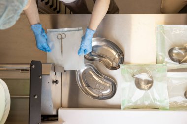 Kliniğin sterilizasyonunda cerrahi aletlerin sterilizasyon ve ambalaj süreci, yukarıdan görüş