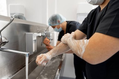 İki cerrah cerrahi bir ameliyata hazırlanırken ellerini dikkatlice yıkadı. Kısırlık ve ameliyat kavramı