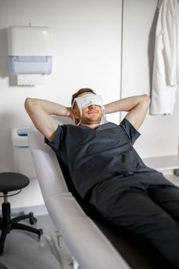 Cerrah sıkı bir çalışmadan sonra dinlenir maske takmış bir yüzle tıbbi kanepede uyur. Bir doktorun yaşam tarzı ve eğlencesi