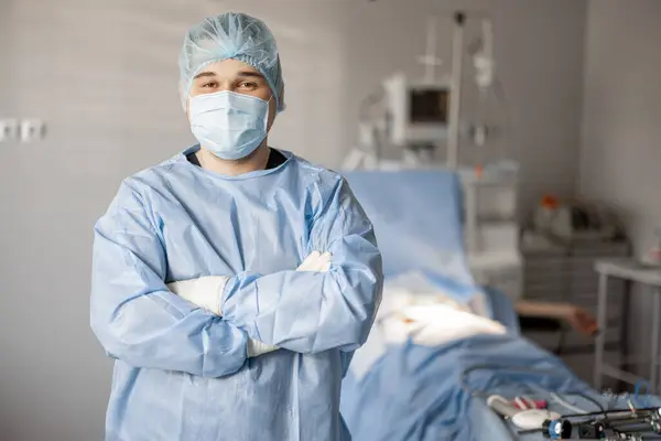 Portrait of a confident surgeon in uniform standing in operating room ready for invasive treatment