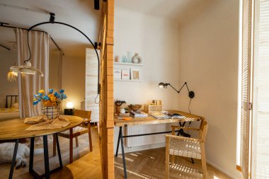 Çalışma odasının iç manzarası ahşap masa, kitaplar ve lambalarla dolu raflar şık stüdyo dairesi.