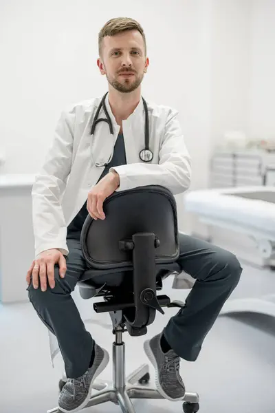 Portrait Young Male Doctor Practitioner Medical Gown Stethoscope Sitting Chair — Stock Photo, Image