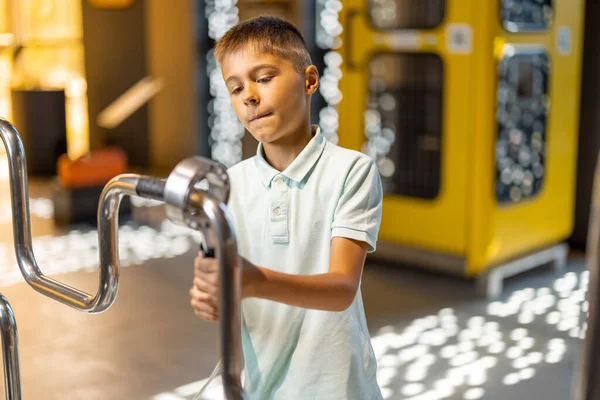 科学博物館のインタラクティブなモデルで物理と電気を研究する小さな少年 児童エンターテインメントと学習の概念 — ストック写真
