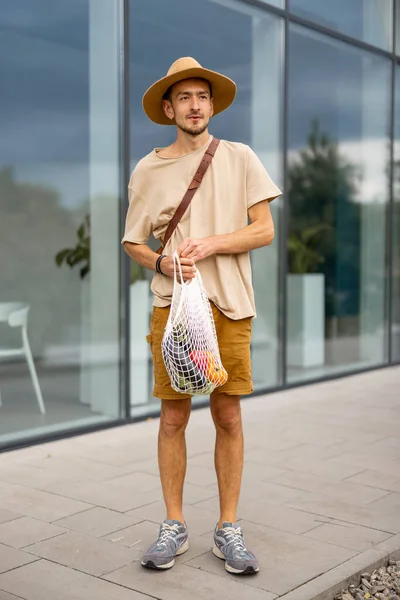 Elegante Hombre Con Sombrero Camina Con Una Bolsa Malla Llena — Foto de Stock