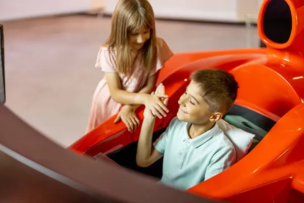 Anak Kecil Mengendarai Simulator Mobil Sport Bermain Dengan Adiknya Taman Stok Lukisan  