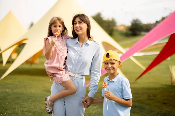 Glückliche Mutter Mit Kleinen Mädchen Und Jungen Besuchen Einen Vergnügungspark Stockbild