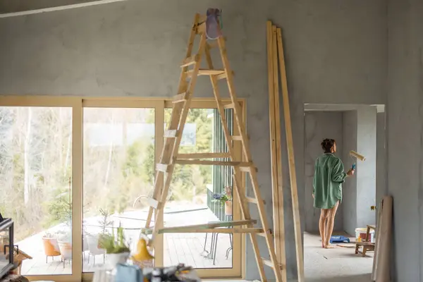 Jonge Vrouw Schildert Muren Terwijl Een Nieuw Huis Repareert Staande Stockfoto