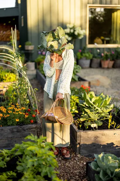 stock image A woman lovingly holds a freshly harvested cauliflower close, enjoying the fruits of her garden. The moment captures the deep connection with nature and the joy of nurturing homegrown produce