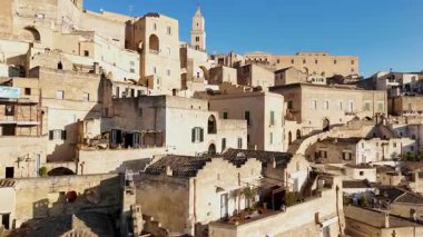 Matera Katedrali 'nin hava aracı görüntüsü antik şehir manzarasının üzerinde yükseliyor. Tarihi kasabanın merkezinde geleneksel taş konutlar ve ortaçağ mimarisi sergileniyor.
