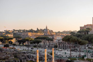 Capitoline Tepesi manzarası, Santi Luca e Martina Kilisesi, ve görkemli Altare della Patria Roma çamları ve kuşların çatılarda süzüldüğü altın ışıkla yıkandı.