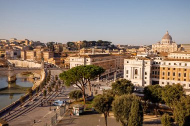 Castel Sant Angelo 'dan Vatikan Şehri ve St. Peters Bazilikası üzerinde geniş çaplı bir manzara, tarihi binalar ve Roma çam ağaçlarıyla çevrili Via della Conciliazione' nin planını ele geçiriyor.