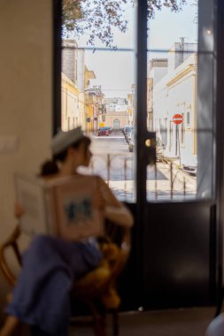 Güneşli bir terasta sakin anlar ve sıcacık bir Akdeniz dairesinde büyük beyaz bir köpek, sağlıklı yiyecekler, açık pencereler ve doğal dokular.