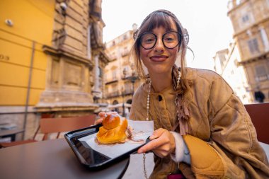 Bir kadın açık havada Sicilya dondurması yemekten hoşlanır, gözleri zevkle kapalıdır. Görüntü duyusal zevki, yavaş yaşam tarzını ve otantik seyahat anlarını besin, seyahat ya da yaşam tarzı için ideal hale getiriyor.