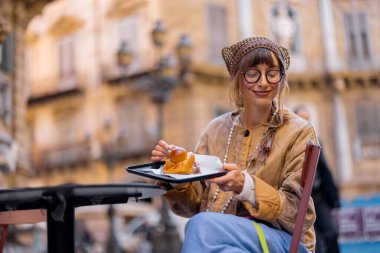 Bir kadın açık havada Sicilya dondurması yemekten hoşlanır, gözleri zevkle kapalıdır. Görüntü duyusal zevki, yavaş yaşam tarzını ve otantik seyahat anlarını besin, seyahat ya da yaşam tarzı için ideal hale getiriyor.