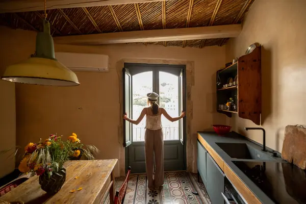 Sicilya 'nın Modica kentinin büyüleyici çatılarına ve tarihi Barok mimarisine bakan genç bir kadın balkonda duruyor. Açık pencereden yansıyan o huzurlu yamacı sessizce alır.