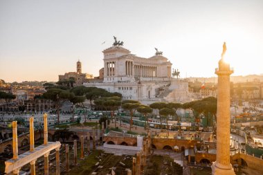 Capitoline Tepesi manzarası, Santi Luca e Martina Kilisesi, ve görkemli Altare della Patria Roma çamları ve kuşların çatılarda süzüldüğü altın ışıkla yıkandı.