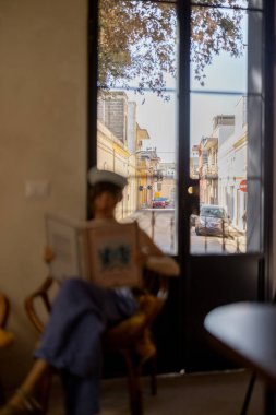 Güneşli bir terasta sakin anlar ve sıcacık bir Akdeniz dairesinde büyük beyaz bir köpek, sağlıklı yiyecekler, açık pencereler ve doğal dokular.