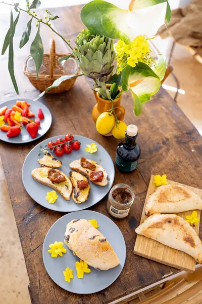 Taze meyve, limon, bruschetta ve zeytinyağlı ahşap bir masada canlı Akdeniz brunch 'ı. Doğal ışık ve rahat açık hava atmosferiyle kırsal yaz manzarası