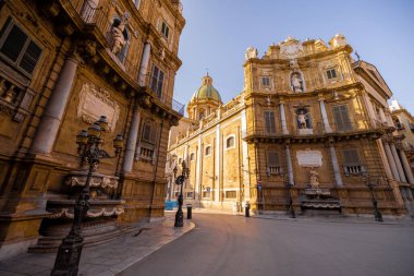 Palermo 'daki Quattro Canti Meydanı' nda altın ışığın barok cepheleri aydınlattığı yerde insanlar geziniyor. Bu fotoğraf, Sicilya 'daki kentsel keşiflerin mimari zarafetini ve cazibesini yansıtıyor.