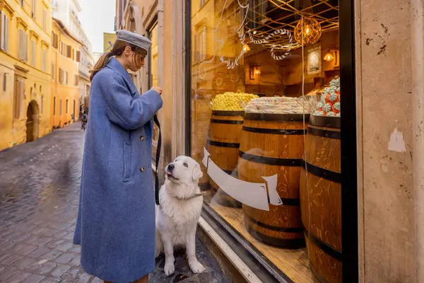 Bir kadın ve köpeği Roma 'da bir ara sokaktaki şeker dükkanına uğruyor. Sıcak tonlarda, ahşap fıçılarda ve tatlı cazibede bu ana her gün sihir eklenir.