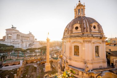 Gün batımı, Roma Forumu 'nun antik kalıntılarını ve Meryem Ana' nın Kutsal Kilisesi 'nin kubbesini silip süpürüyor. Uzakta Altare della Patria var.