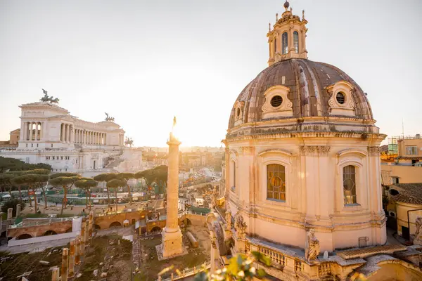 Gün batımı, Roma Forumu 'nun antik kalıntılarını ve Meryem Ana' nın Kutsal Kilisesi 'nin kubbesini silip süpürüyor. Uzakta Altare della Patria var.