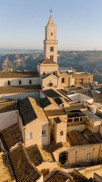 Matera, İtalya 'nın havadan görünüşü, altın sabah ışığıyla yıkanmış. Kanyon üzerinde yükselen ikonik taş evler ve katedral kulesi UNESCO tarafından listelenmiş bu tarihi harikayı gözler önüne seriyor.