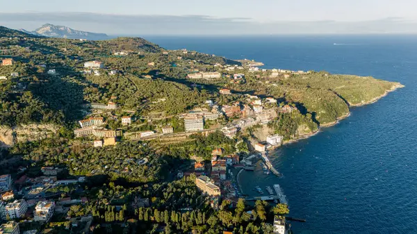 İtalya 'nın Sorrento kenti yakınlarındaki manzaralı sahil manzarası, yemyeşil tepeler, geleneksel limon bahçeleri ve derin mavi denize bakan Akdeniz villaları.